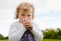 Girl holding daisies and looking at camera — Stock Photo