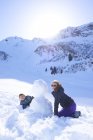 Fratelli che fanno un pupazzo di neve, Hintertux, Tirolo, Austria — Foto stock