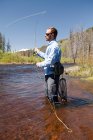 Vista laterale dell'uomo pesca a mosca nel fiume, Colorado, USA — Foto stock