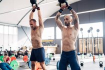 Männer-Gewichtheben mit Wasserkocher in Turnhalle — Stockfoto