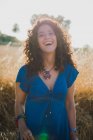 Portrait of curly woman laughing in field — Stock Photo