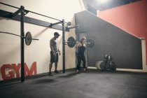 Frau im Fitnessstudio beim Gewichtheben mit Langhantel — Stockfoto