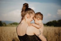 Mulher com bebê menina no campo de grama dourada, Arezzo, Toscana, Itália — Fotografia de Stock