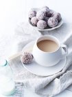 Vista ravvicinata di latte, cacao e deliziose palline di mirtillo sul tavolo — Foto stock