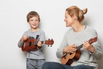 Мать и сын играют на укулеле — стоковое фото
