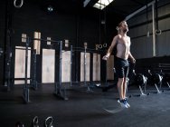 Homem se exercitando no ginásio, pulando com corda de velocidade — Fotografia de Stock
