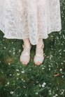 Mujer de pie sobre hierba cubierta de flores - foto de stock