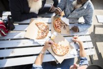 Amis manger de la pizza à l'extérieur — Photo de stock