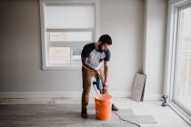 Mann mischt Zement in Eimer mit Handmixer — Stockfoto