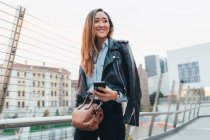 Mujer de negocios caminando con smartphone en la mano - foto de stock