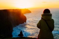 Жінка дивиться захід сонця, Лісканор, Клер, Ірландія — стокове фото