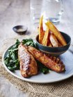 Cajun chicken with chard and sweet potato chips — Stock Photo