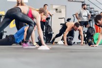Groupe moyen de personnes s'entraînant en salle de gym — Photo de stock