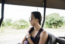 Side view of Young female tourist looking out bus on game drive trip, Botswana, Africa — Stock Photo