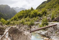 Mann überquert Fluss auf Rohrbrücke, verfluchte Berge, theth, shkoder, Albanien, Europa — Stockfoto