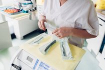 Жінка-стоматолог в стоматологічному кабінеті, готує стоматологічне обладнання, середня секція — стокове фото
