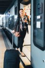 Жінка з колісною валізою посадки в поїзді — стокове фото