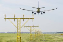 Avión aterrizando por las luces de aterrizaje de pista, Schiphol, Holanda del Norte, Países Bajos, Europa - foto de stock