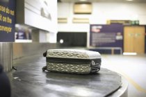 Колесный чемодан на карусели в аэропорту — стоковое фото