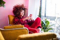 Junge Frau nutzt Smartphone im Haus — Stockfoto