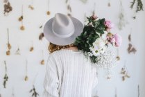 Back view of Woman holding bunch of flowers — Stock Photo