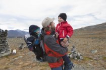 Пешеход с сыновьями в горном ландшафте, Национальный парк Йотунхеймен, Лом, Оппланд, Норвегия — стоковое фото
