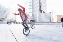 Male BMX Biker doing stunt in urban area — Stock Photo