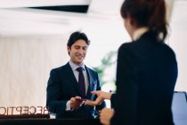 Geschäftsmann checkt an Hotelrezeption ein — Stockfoto