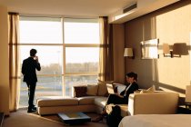 Uomo d'affari e donna d'affari che lavorano nella camera da letto dell'hotel — Foto stock