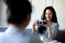 Young woman photographing friend whilst having breakfast in boutique hotel in Italy — Stock Photo