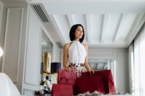 Fashionable woman with shopping bags in suite — Stock Photo
