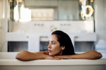 Frau entspannt sich in Badewanne in Suite — Stockfoto