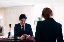 Empresário que faz o check-in na recepção do hotel — Fotografia de Stock