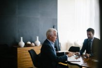 Due uomini d'affari che si riuniscono al tavolo del consiglio — Foto stock