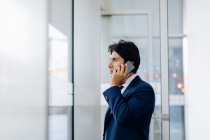 Бизнесмен использует смартфон в офисном здании — стоковое фото