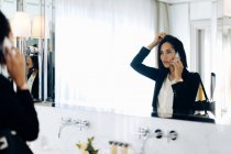 Businesswoman using smartphone in bathroom of suite — Stock Photo
