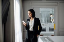 Mulher de negócios usando smartphone em suite — Fotografia de Stock