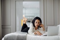 Geschäftsfrau nutzt Smartphone und Laptop in der Suite — Stockfoto