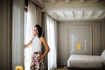 Модна жінка біля вікна в номері — стокове фото