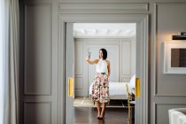 Donna alla moda che prende selfie in suite — Foto stock