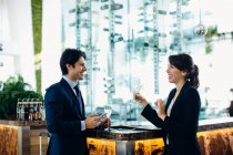 Geschäftsmann und Geschäftsfrau trinken an Bar — Stockfoto