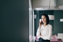 Молода бізнес-леді в готелі робить дзвінок на смартфон — стокове фото