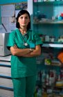 Portrait of female surgeon wearing scrubs standing in operating theatre. — Stock Photo