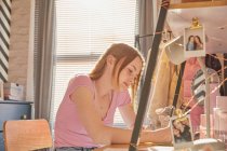 Teenagermädchen sitzt in ihrem Zimmer an einem Schreibtisch und macht Hausaufgaben. — Stockfoto
