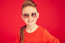 Felice sorridente ragazza bruna indossa gli occhiali da sole e posa sulla macchina fotografica — Foto stock
