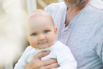 Portrait of baby girl held by a man. — Stock Photo