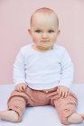 Portrait of baby girl on pink background. — Stock Photo