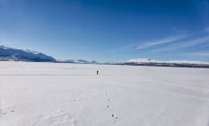 Distant view of boy walking on frozen lake in Vasterbottens Lan, Sweden. — Stock Photo