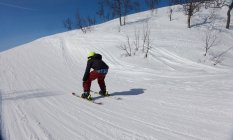 Rückansicht eines Jungen beim Skifahren auf einer Piste in Vasterbottens Lan, Schweden. — Stockfoto