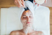 Mujer recibiendo un tratamiento facial en un salón de belleza. - foto de stock
